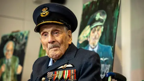 Royal Air Force An RAF pilot in full uniform, navy jacket and hat with gold trim, and numerous colourful badges