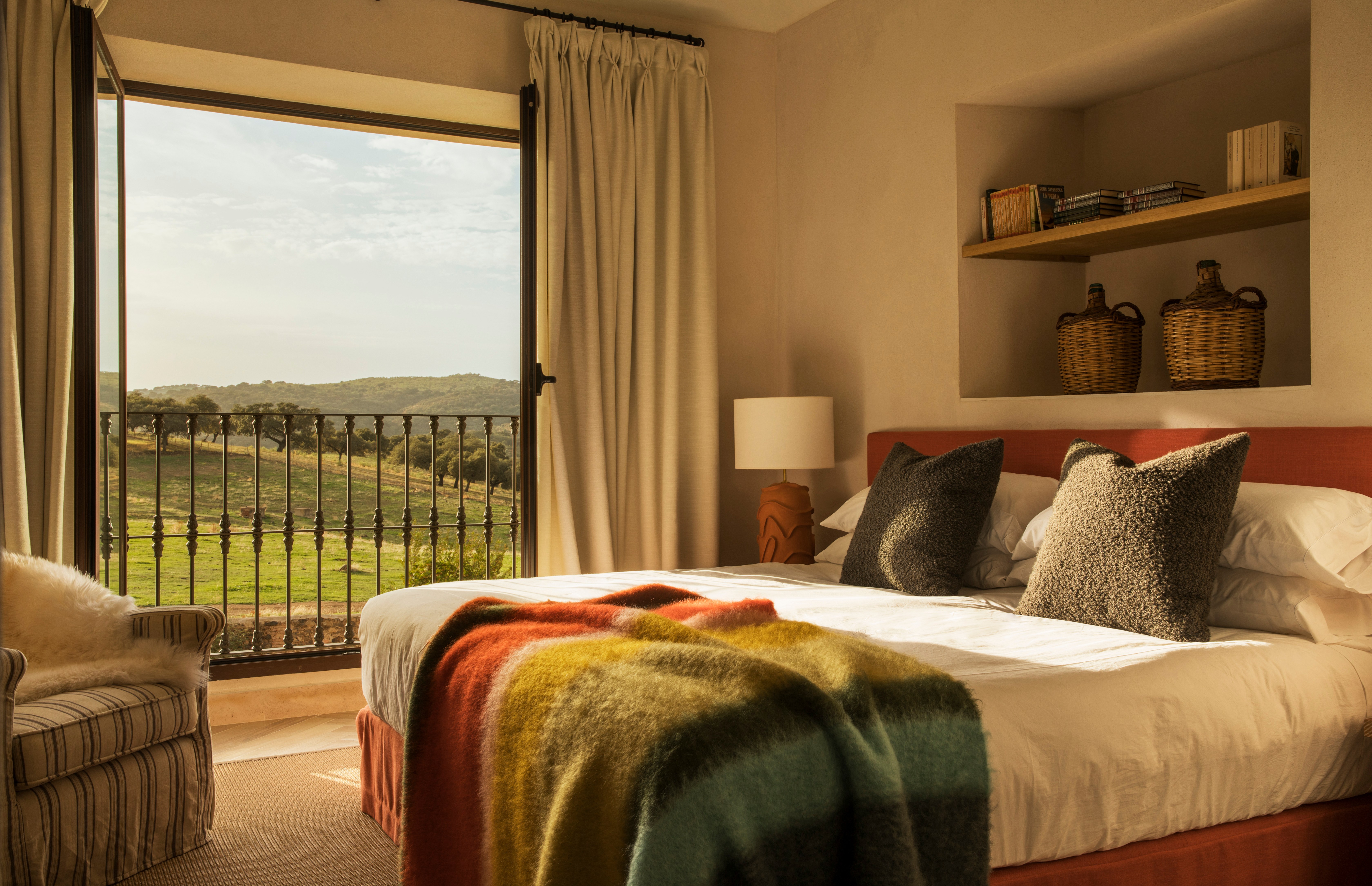 Bedroom with a view of a grassy hillside.