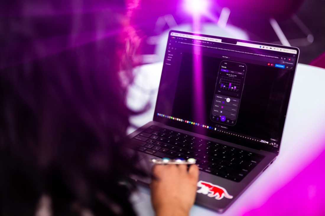 A photograph taken over Mukki Gill of her working on her laptop.
