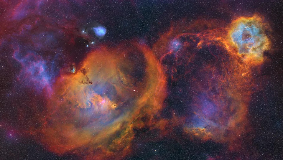two colorful nebulae swirl near each other