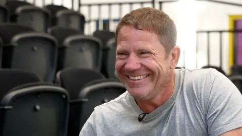 John Fairhall/BBC Steve Backshall is pictured smiling and wearing a light coloured T shirt