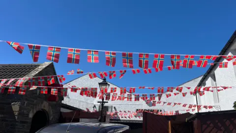 A string of Orkney flags, red, bule and yellow coloured.