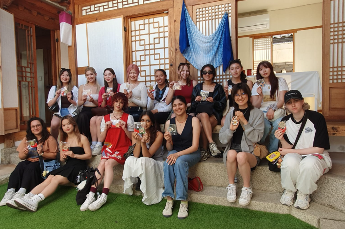 A group of students posing on the steps of a building in Korea.