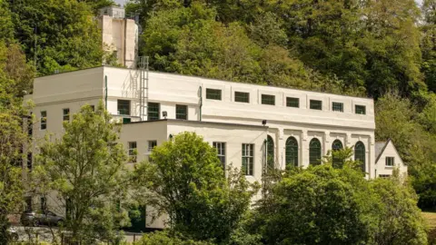 Drax A nearly century old hydro power station building pokes out from between the trees