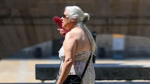 Getty Images A woman fans herself during the June heatwave in Madrid
