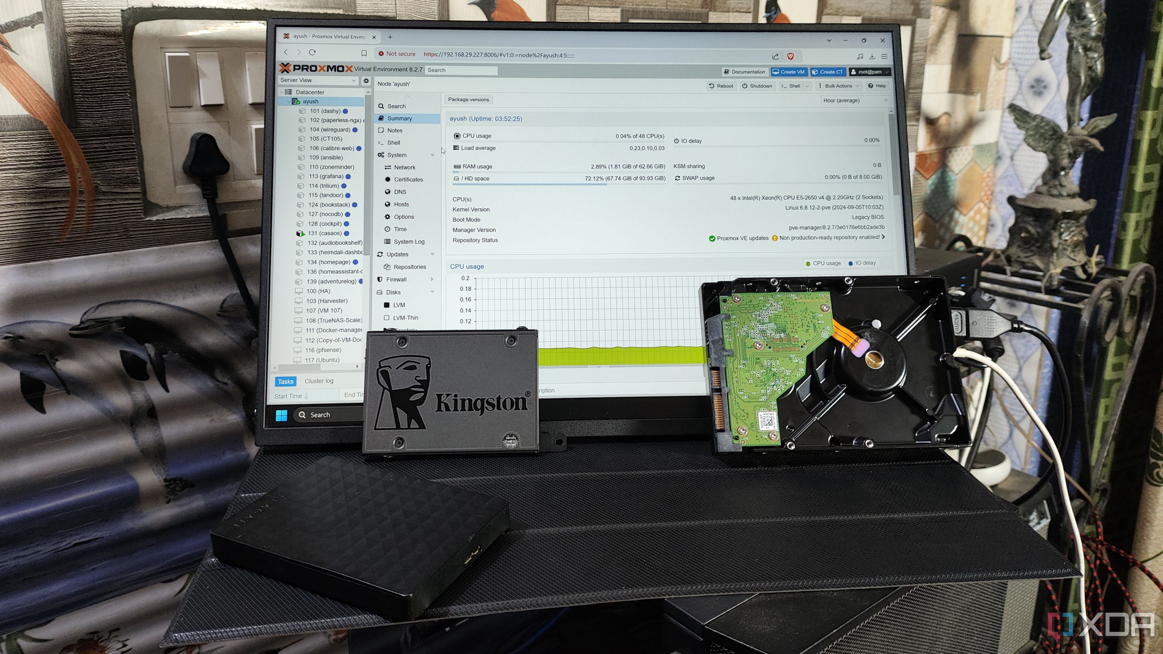 Some HDDs and a Kingston SSD placed in front of a monitor displaying the Proxmox web UI