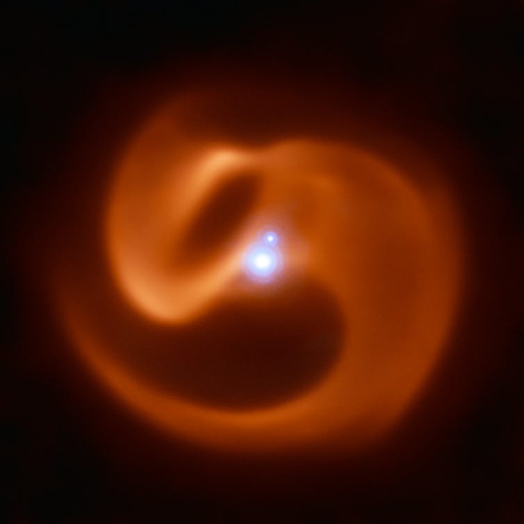 An orange swirl on a black background with a blue dot in the middle.