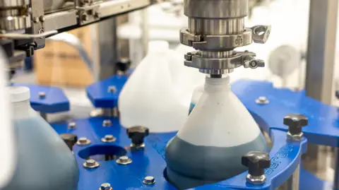 Sensient A plastic beaker being filled with a blue dye