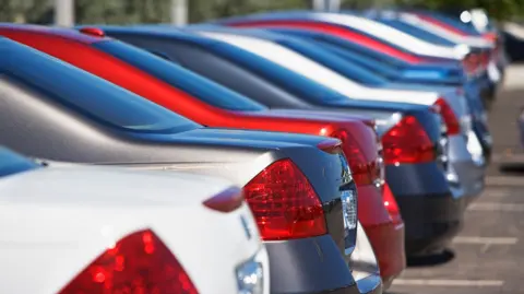 Getty Images A row of cars sit in a car park in a car park.