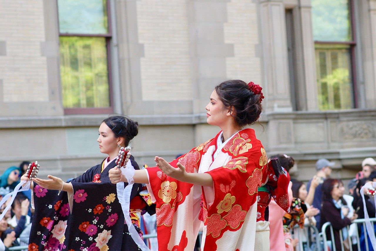 A procession of groups showcasing traditional Japanese culture, including dances, kimono, martial arts, and taiko drumming. (© Kasumi Abe)