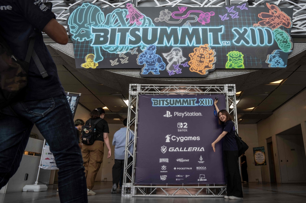 A visitor poses with a signage during the BitSummit indie gaming expo in Kyoto July 18, 2025. — AFP pic