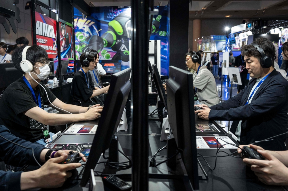 Visitors play video games during the BitSummit indie gaming expo in Kyoto July 18, 2025. — AFP pic