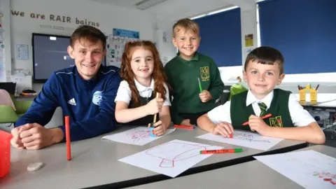 Partner School Programme Football coach Danny Strachan with school pupils.