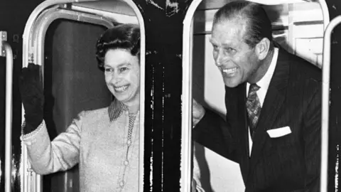 Getty Images Queen Elizabeth II and her husband Prince Philip, Duke of Edinburgh, smile and wave as the Royal train pulls out of Euston n 1977