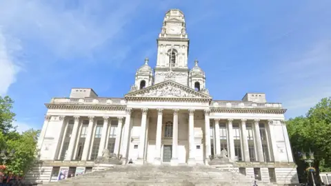 Google A Google Street View of Portsmouth Guildhall, a large white building with large columns in the Ancient Greek style.