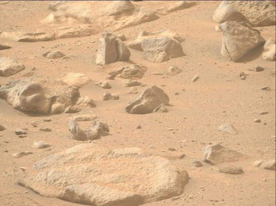 a large rock in the middle of a desert