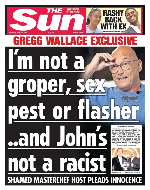 Former MasterChef presenter Gregg Wallace wears a blue shirt and silver spectacles and touches his brow as he speaks. 
