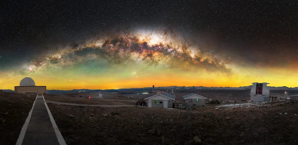 the milky way over a rural area and observatory