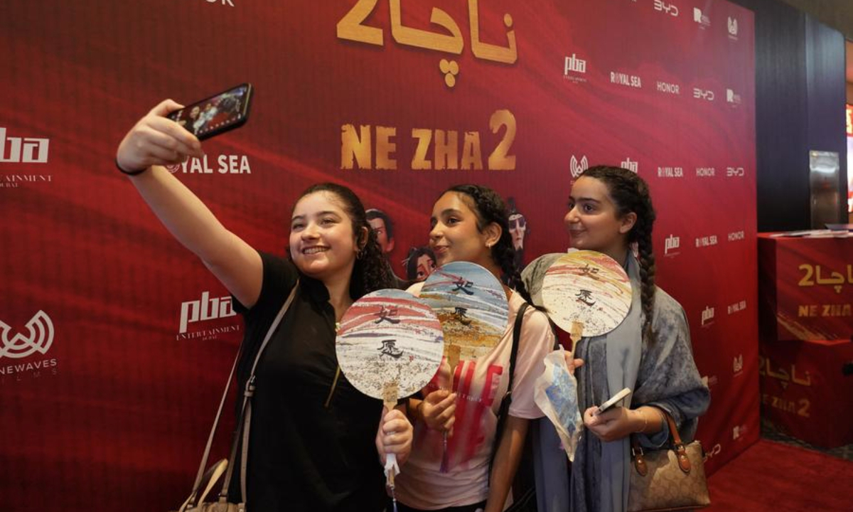 Girls take a selfie in front of a promotional display for the premiere of Chinese animated blockbuster Ne Zha 2 in Riyadh, Saudi Arabia on June 25, 2025. (Xinhua/Luo Chen)