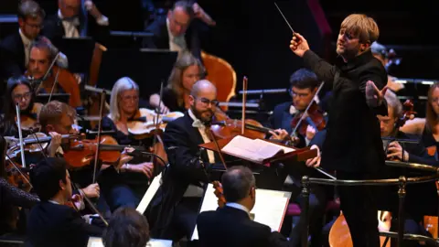 BBC A conductor leads an orchestra during a performance at the Royal Albert Hall.