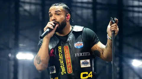Getty Images Drake holding a microphone stand