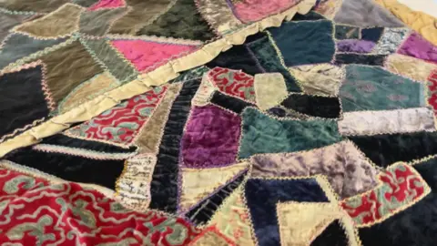 Aisha Iqbal/BBC A colourful patchwork quilt in close-up