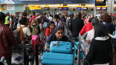 Reuters Passengers wait in line at Heathrow Airport, after radar failure led to the suspension of outbound flights across the UK