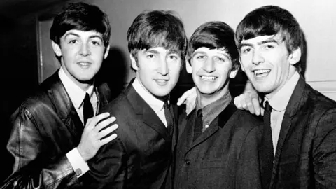 PA Media A black and white image of Paul McCartney, John Lennon, Ringo Starr and George Harrison taken in 1963. The men are all in black jackets, shirts and ties.