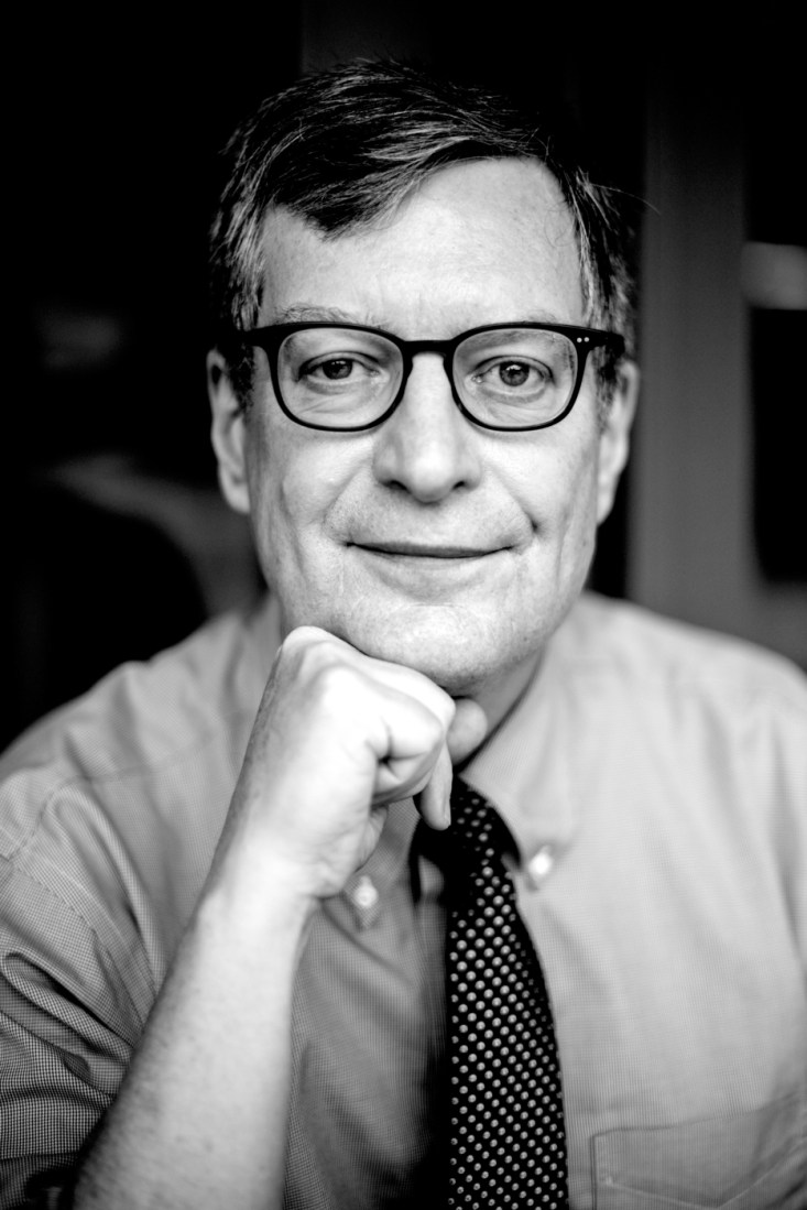 Portrait of Dan Kennedy, wearing a shirt and tie and smiling.