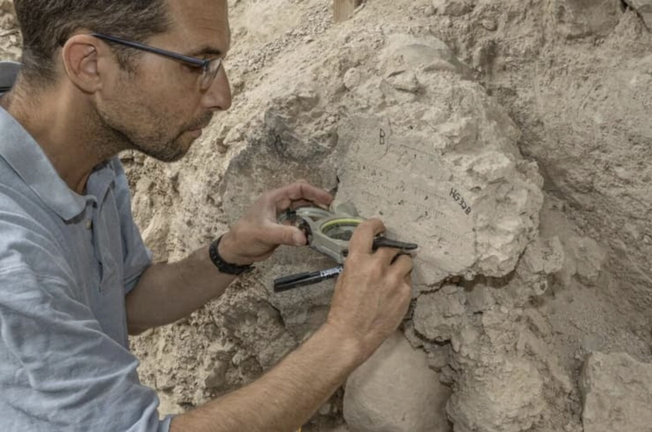 a man takes samples from a rock