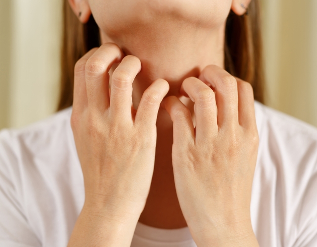 Hands scratching skin on neck