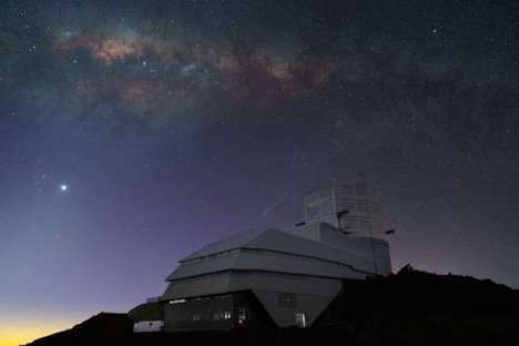 Image of an observatory on a mountain peak, with the milky way galaxy in the sky.