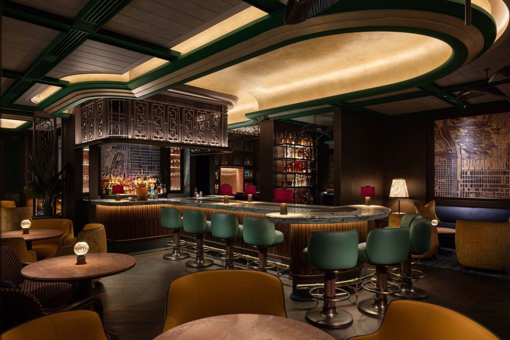 Luxurious hotel bar with a curved marble counter, art deco details, plush seating, and warm ambient lighting. Canes & Tales, Waldorf Astoria Osaka. Hilton