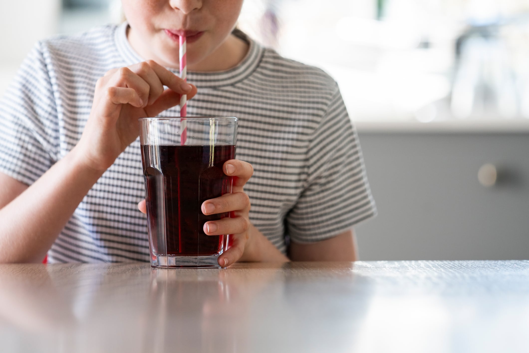Child drinking sugary soft drink, which new research says have long-lasting health impact on children's health