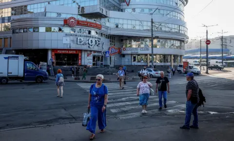 Reuters People walk across a zebra crossing outside a shopping mall in Kyiv on Thursday.