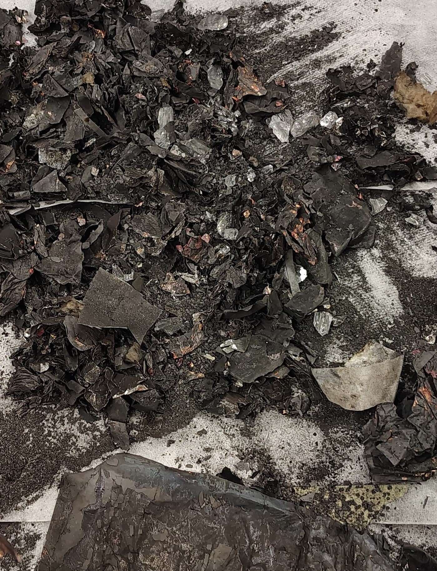 A lab photo shows charred battery remains after an explosion.
