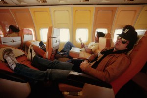 Singer and pianist Billy Joel rests on an airline flight between Austin and Dallas during a tour promoting his "57th Street" album. | Location: Above Texas, USA.  (Photo by © Wally McNamee/CORBIS/Corbis via Getty Images)