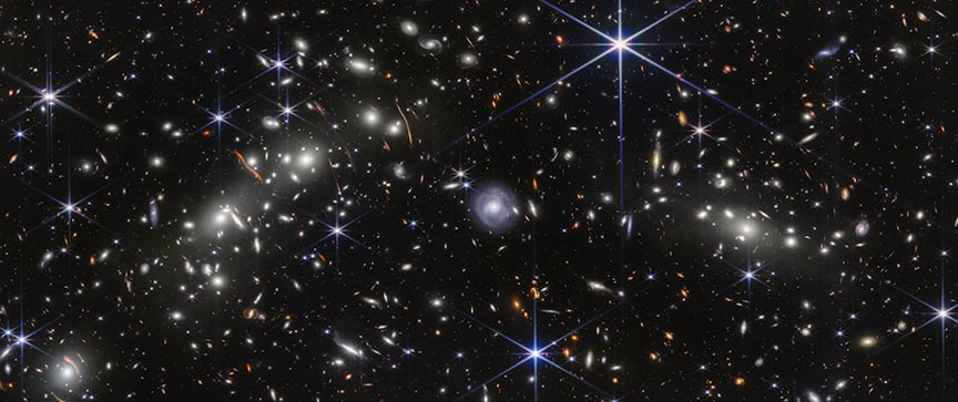 The Webb NIRCam view of the Bullet Cluster, showing an infrared look at distant galaxies, with their images deformed by the gravitational effect of the dark matter. Credit: Near-infrared: NASA/ESA/CSA/STScI; Image processing: NASA/STScI/J. DePasquale