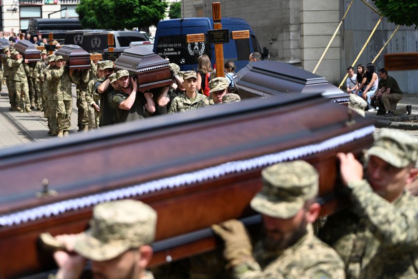 Ukrainian soldiers carry the coffins of twelve Ukrainian servicemen and prisoners of war who died being held in Russian captivity during a funeral ceremony in Lviv, western Ukraine, on July 25.