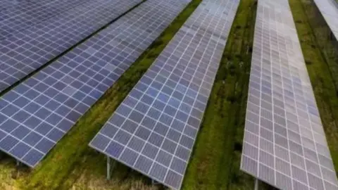 Getty Images Solar panels in a green field