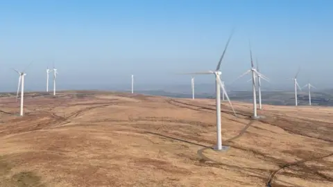 Cubico A computer generated image of the proposed Scout Moor Two windfarm. There are several large white turbines spaced out across the moor.