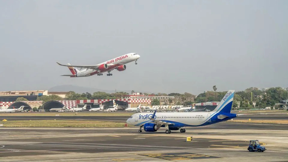 The image shows an IndiGo aircraft on the runway after landing whilst an Air India plane takes off at Chhatrapati Shivaji Maharaj International Airport in Mumbai. 