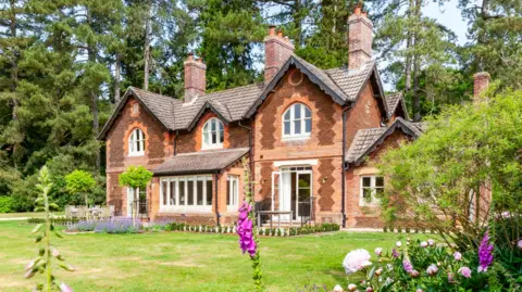 Oliver's Travels External view of The Gardens House. It is a large building with ornate brick work and lots of chimeys. 
