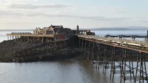 Getty Images Looking across to Birnbeck Pier from the shore on an overcast day. The pier is dilapidated and looks neglected