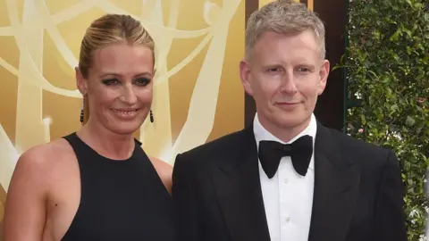 Getty Images Cat Deeley and Patrick Kielty pose in front of yellow background.