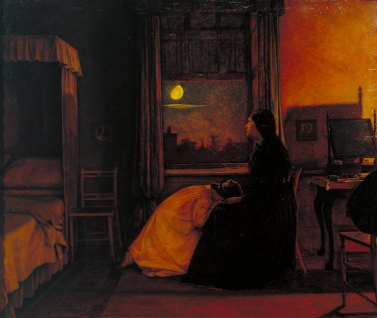 A woman weeps into another woman's lap