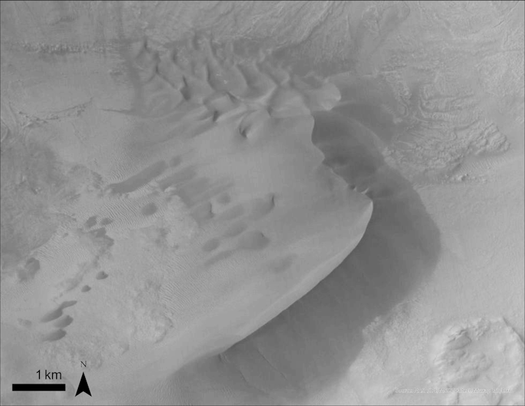 A black and white aerial image of a dune on Mars.