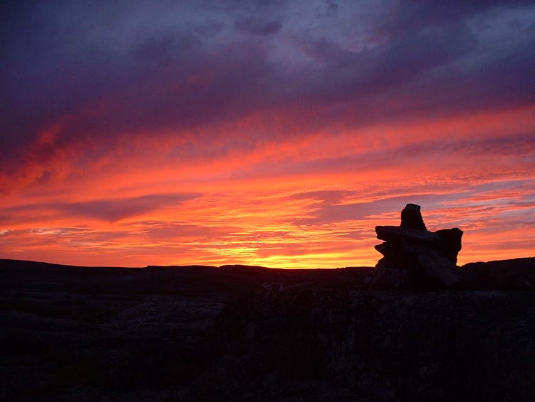 a rocky landscape silhouetted by sunset