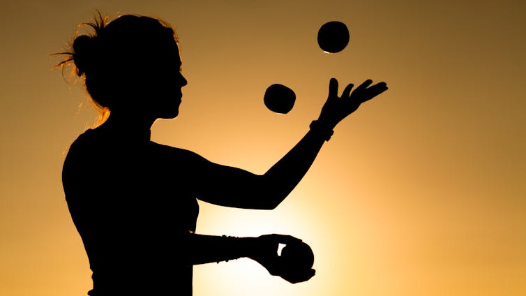 Silhouette of a Woman Juggling with Balls at Sunset