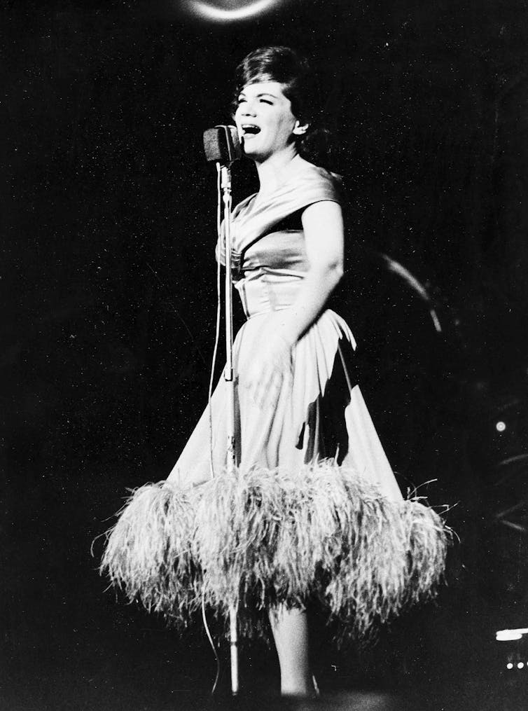 Black and white photo, Francis at the microphone.